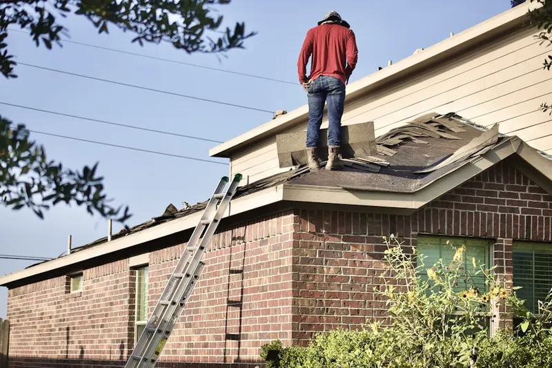 Professional roofer working on a residential roof in Northwest Duxbury